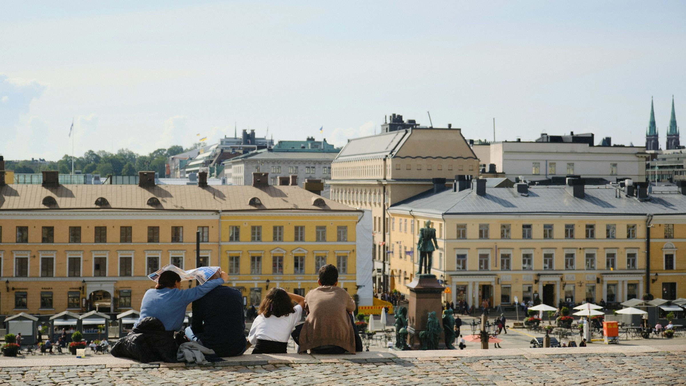 Four people sitting down overlooking Senate Square in Helsinki.